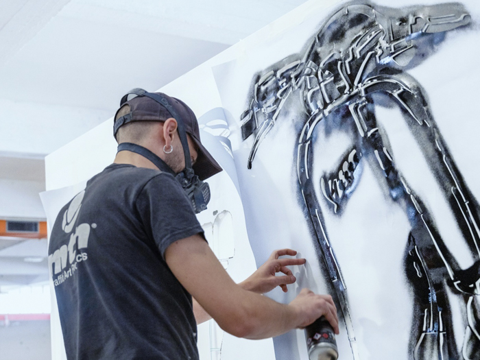 Immagine di no titolo: una persona al lavoro su un’opera in bianco e nero